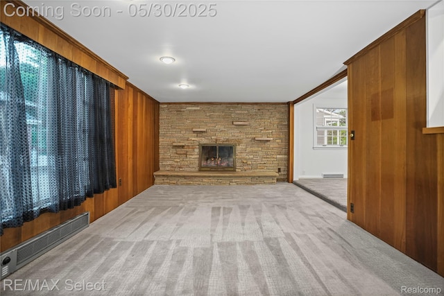 2302 Radcliffe Ave, Flint, MI 48503 - unfurnished living room with carpet flooring, wood walls, and a stone fireplace