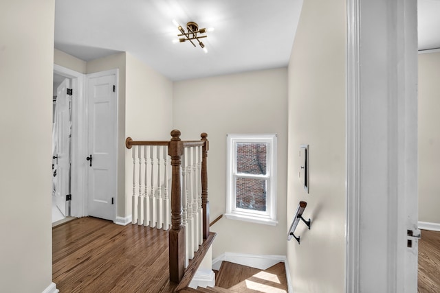 stairway with wood finished floors and baseboards