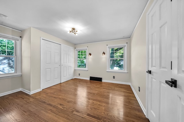 unfurnished bedroom featuring wood finished floors and baseboards