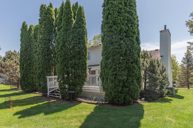 5835 S Ashford Way, Ypsilanti, MI 48197 - view of property exterior with a lawn, a chimney, a wooden deck, and central AC