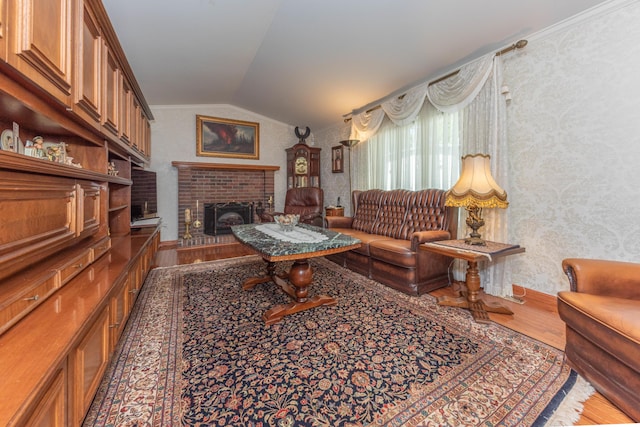 5835 S Ashford Way, Ypsilanti, MI 48197 - living room featuring wood finished floors, vaulted ceiling, wallpapered walls, and a brick fireplace