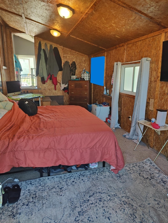 bedroom with wood walls, carpet, and vaulted ceiling