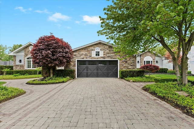 3767 Carrie Ln, Walled Lake, MI 48390 - view of front of property with decorative driveway, an attached garage, and stone siding