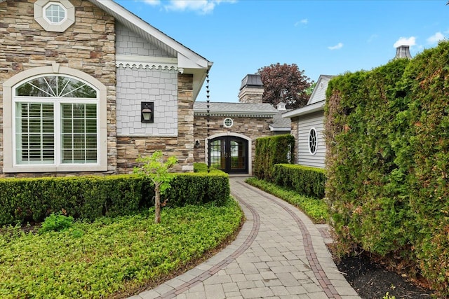 3767 Carrie Ln, Walled Lake, MI 48390 - entrance to property with stone siding, french doors, and a chimney
