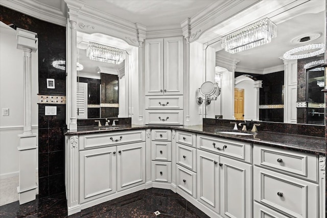 3767 Carrie Ln, Walled Lake, MI 48390 - bathroom with granite floors, double vanity, ornate columns, ornamental molding, and a chandelier
