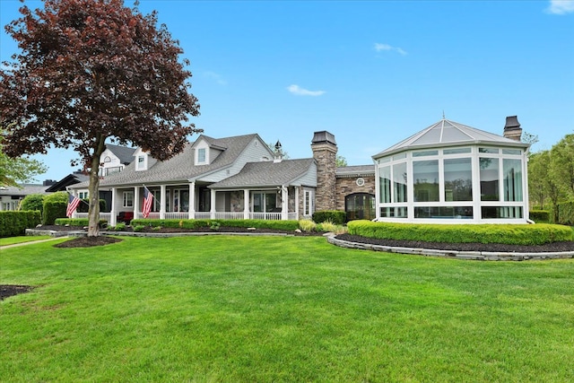 3767 Carrie Ln, Walled Lake, MI 48390 - view of front of house with a sunroom, a front lawn, and a chimney