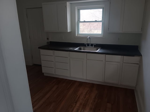1517 Tacoma St, Flint, MI 48503 - kitchen featuring a sink, dark countertops, dark wood-type flooring, and white cabinetry