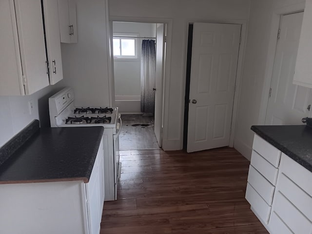 1517 Tacoma St, Flint, MI 48503 - kitchen featuring gas range gas stove, dark countertops, dark wood finished floors, and white cabinetry