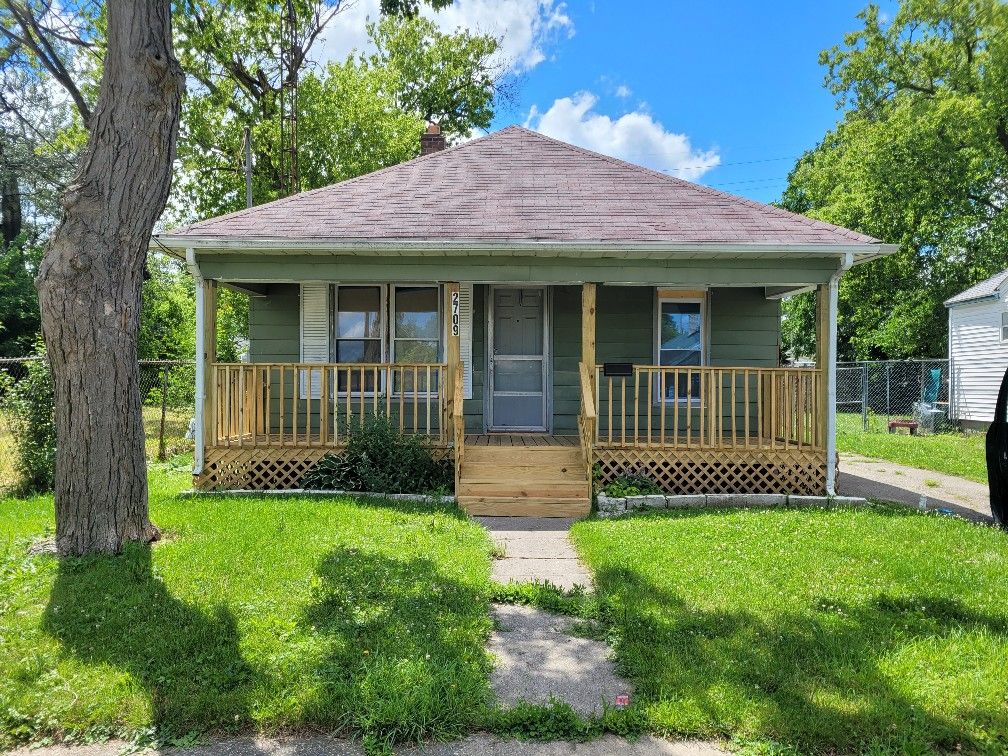 view of front of property with a porch, a chimney, and roof with shingles