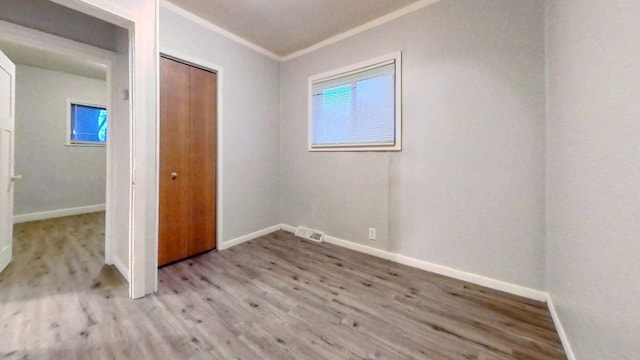 11376 Rivard Ave, Warren, MI 48089 - unfurnished bedroom with wood finished floors, baseboards, a closet, and crown molding
