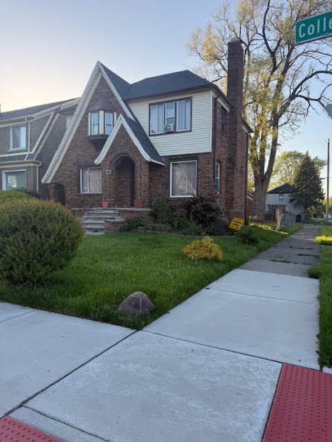 11101 College St, Detroit, MI 48205 - tudor-style house with a chimney, a lawn, and brick siding