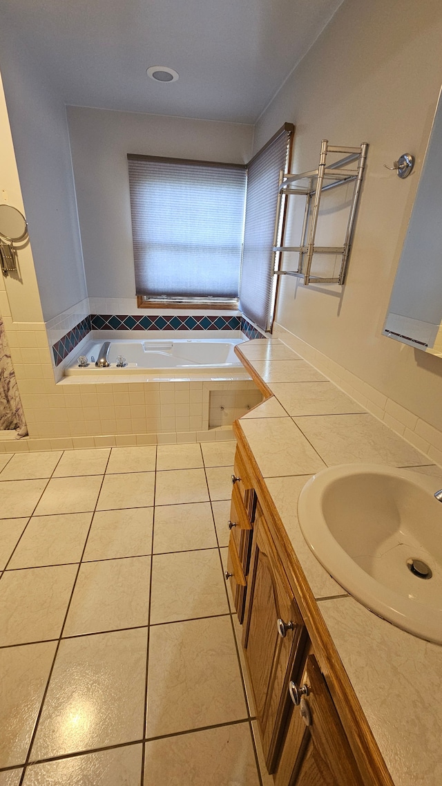 bathroom featuring a garden tub, vanity, and tile patterned flooring