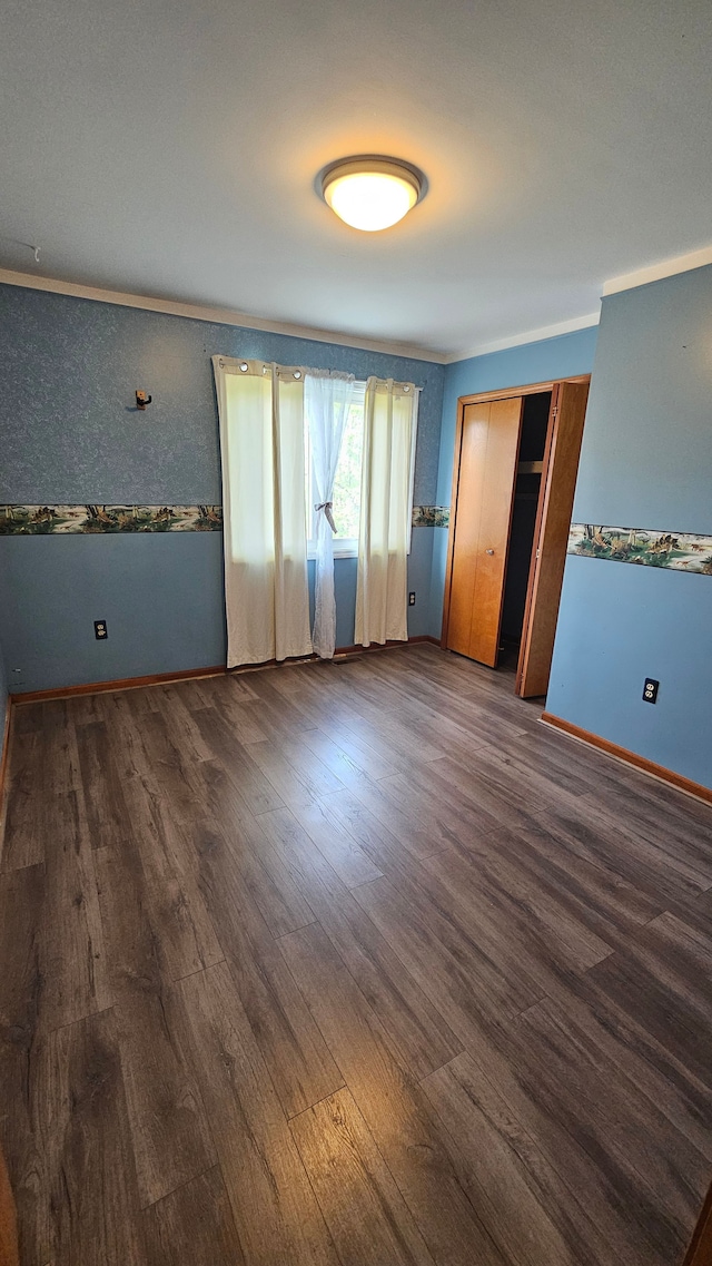unfurnished bedroom featuring wood finished floors and baseboards