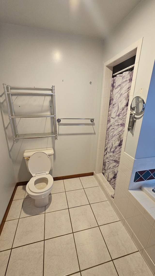 bathroom featuring toilet, tile patterned floors, baseboards, and a shower with curtain