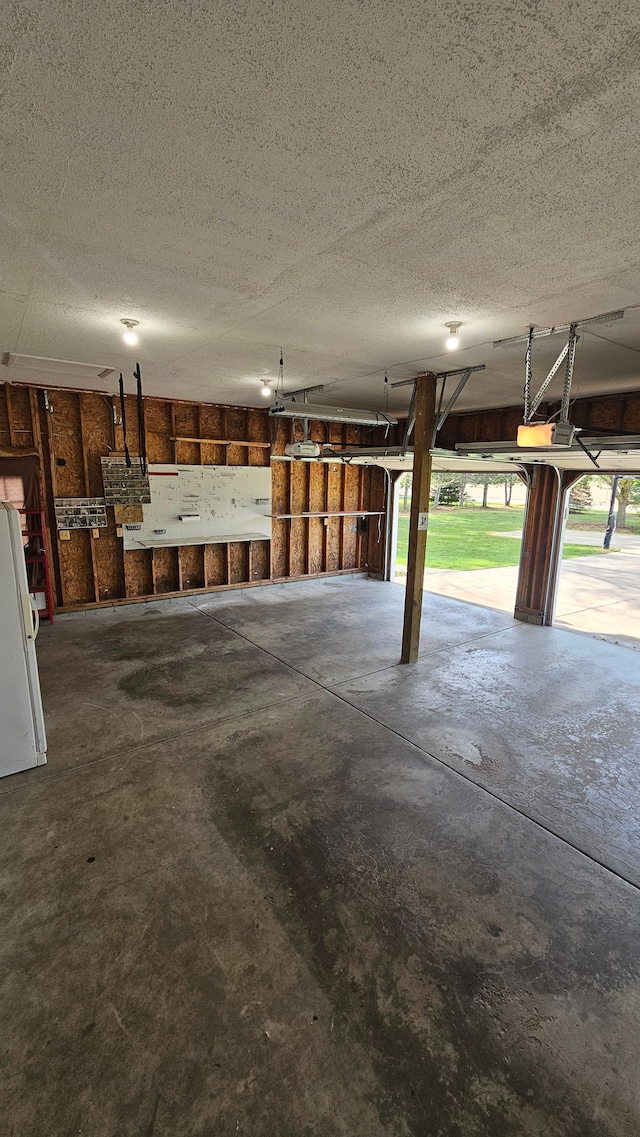 garage with a garage door opener and freestanding refrigerator