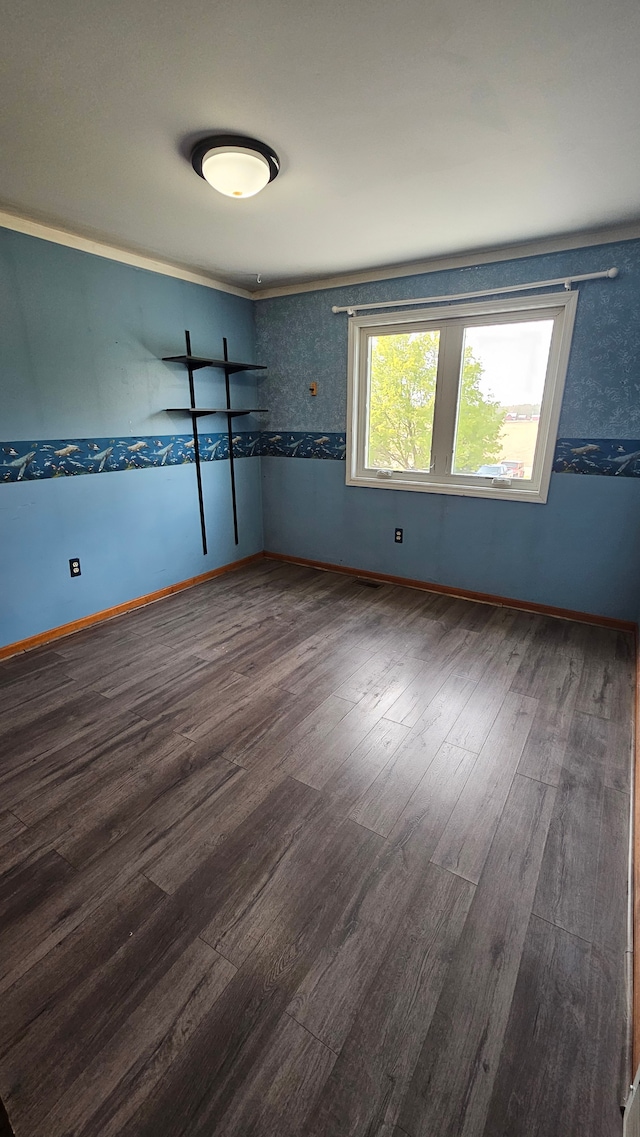 empty room featuring wood finished floors and baseboards