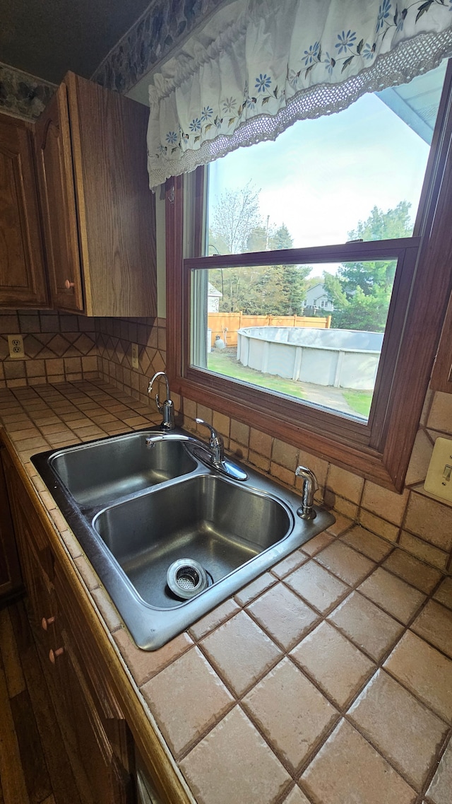 kitchen with tile countertops, a sink, and tasteful backsplash