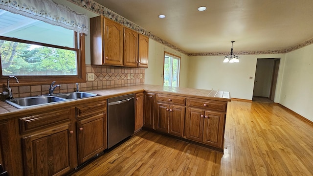 kitchen featuring stainless steel dishwasher, tile countertops, a sink, a peninsula, and recessed lighting