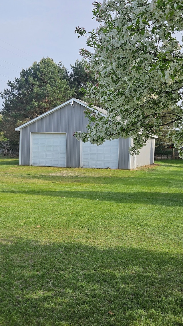 view of grassy yard with an outdoor structure and a garage