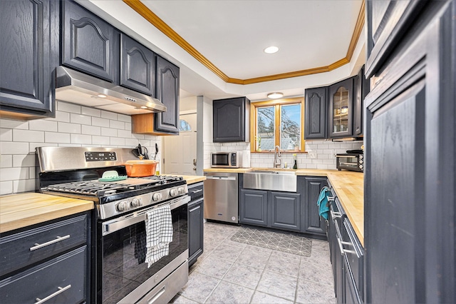 151 Rosetta Ct, Auburn Hills, MI 48326 - kitchen with appliances with stainless steel finishes, butcher block countertops, under cabinet range hood, a sink, and crown molding