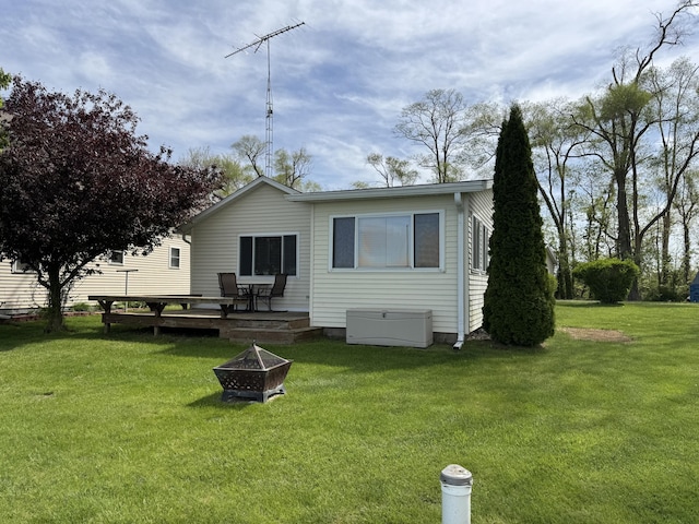 820 N Werners Landing Dr, Bronson, MI 49028 - back of property with an outdoor fire pit, a lawn, and a wooden deck
