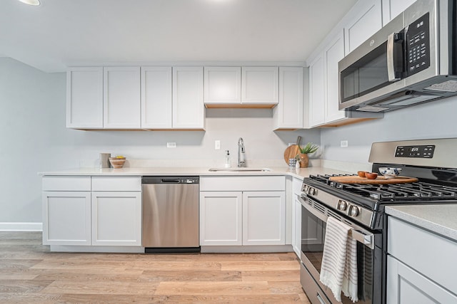 3320 Spinnaker Ln Unit 13B, Detroit, MI 48207 - kitchen featuring stainless steel appliances, a sink, light wood-style floors, white cabinets, and light countertops