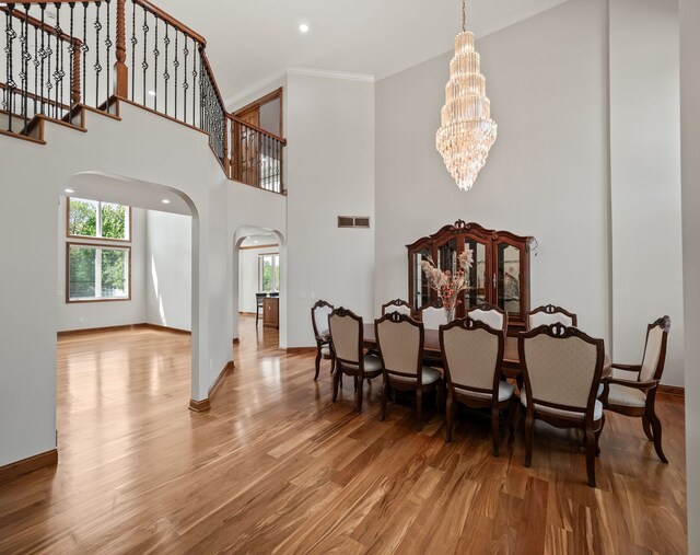 1334 Larayne Dr, Troy, MI 48085 - dining space featuring arched walkways, a chandelier, wood finished floors, plenty of natural light, and crown molding