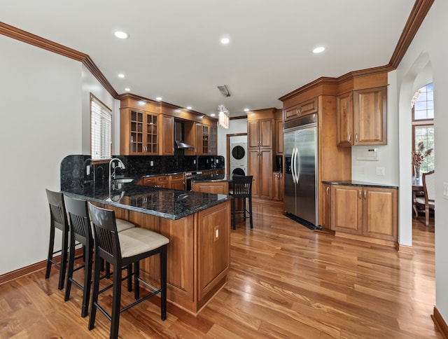1334 Larayne Dr, Troy, MI 48085 - kitchen with stainless steel appliances, stacked washer / drying machine, crown molding, backsplash, and a breakfast bar area