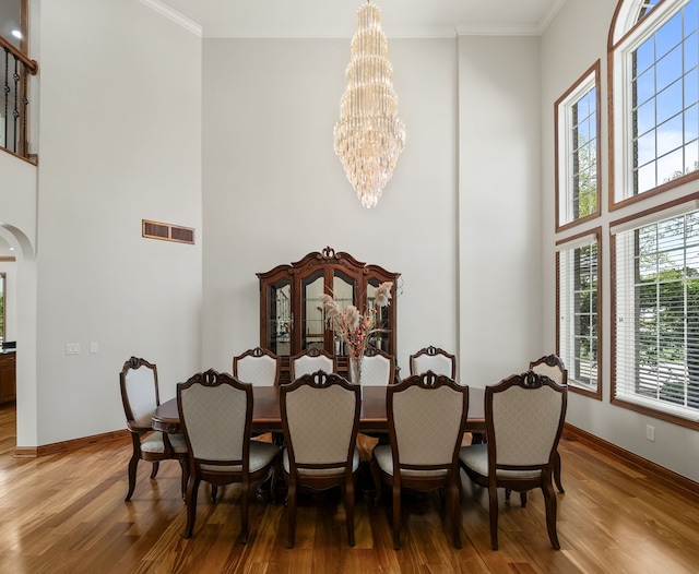 1334 Larayne Dr, Troy, MI 48085 - dining space with a towering ceiling, a chandelier, wood finished floors, crown molding, and baseboards