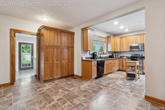 101 Hill St, Stockbridge, MI 49285 - kitchen featuring stainless steel appliances, baseboards, a sink, recessed lighting, and a textured ceiling