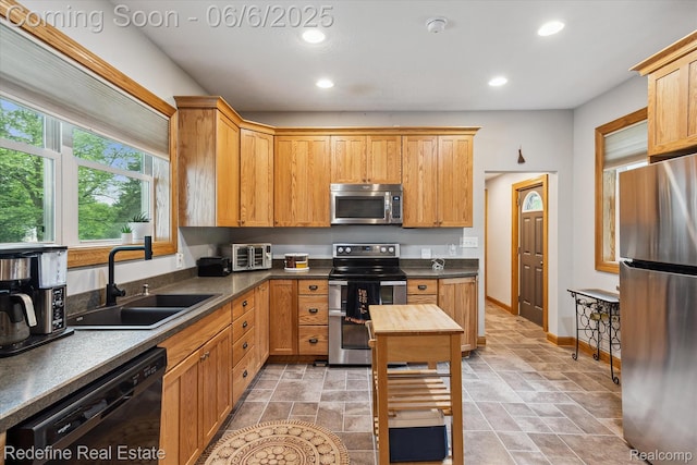 101 Hill St, Stockbridge, MI 49285 - kitchen featuring stainless steel appliances, a sink, recessed lighting, dark countertops, and baseboards