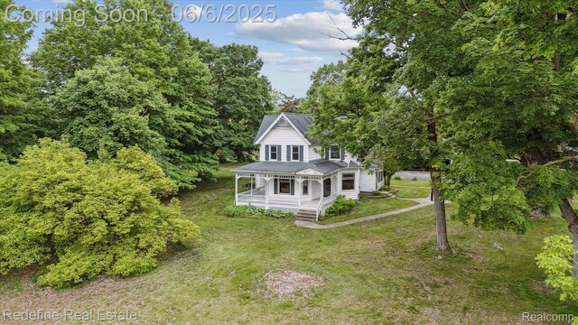 101 Hill St, Stockbridge, MI 49285 - view of front facade featuring a porch and a front lawn
