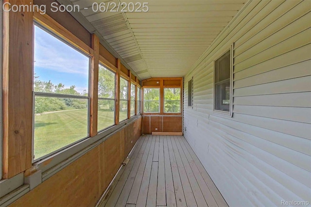 3749 Chase Lake Rd, Howell, MI 48855 - unfurnished sunroom featuring wood walls, wood-type flooring, and vaulted ceiling