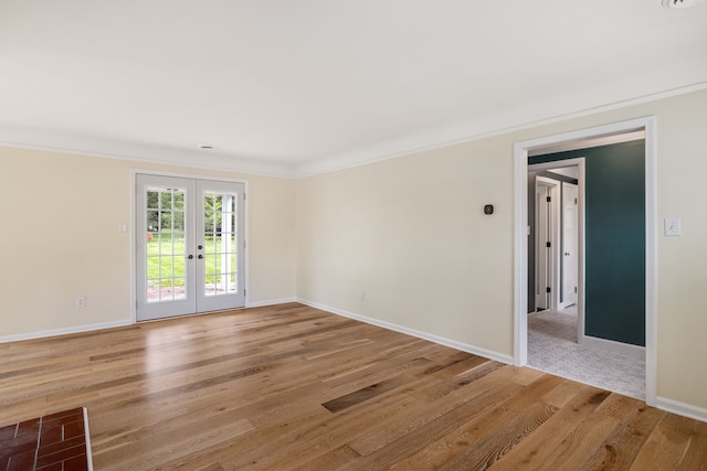 unfurnished room with french doors, ornamental molding, light wood-style floors, and baseboards