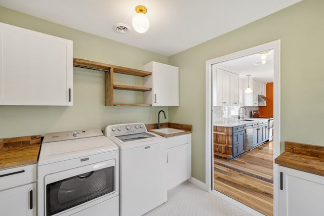 clothes washing area featuring washer and dryer and cabinet space