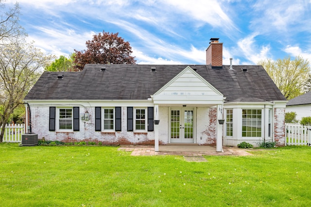 rear view of property with french doors, brick siding, a chimney, central AC unit, and a patio