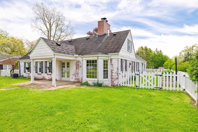 rear view of house featuring brick siding, a patio area, french doors, a chimney, and roof with shingles