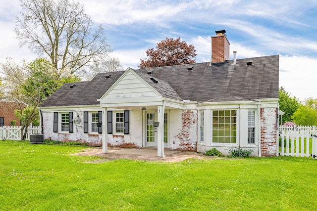 back of house featuring brick siding, a chimney, a patio, and a shingled roof