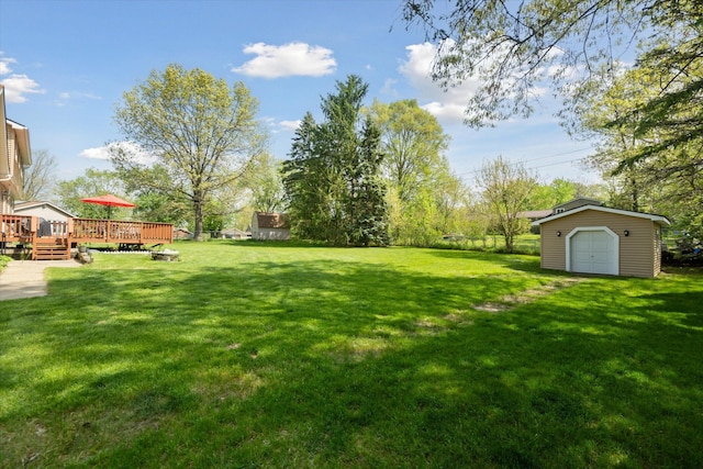 view of green lawn featuring a deck and an outdoor structure