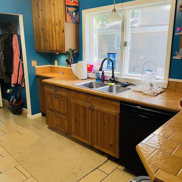 326 N Oak St, Owosso, MI 48867 - kitchen featuring black dishwasher, a sink, brown cabinets, and tile countertops