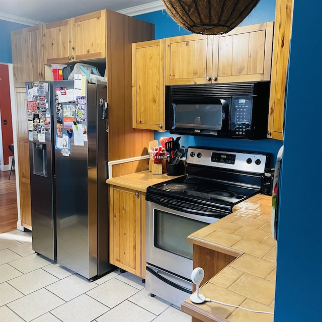 326 N Oak St, Owosso, MI 48867 - kitchen with stainless steel appliances, tile countertops, ornamental molding, light tile patterned floors, and light brown cabinetry