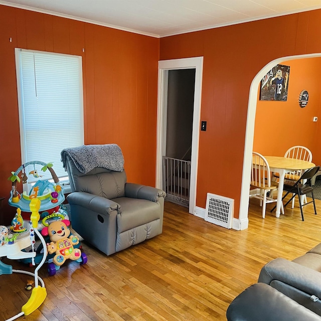 326 N Oak St, Owosso, MI 48867 - living area with light wood-type flooring, crown molding, and arched walkways