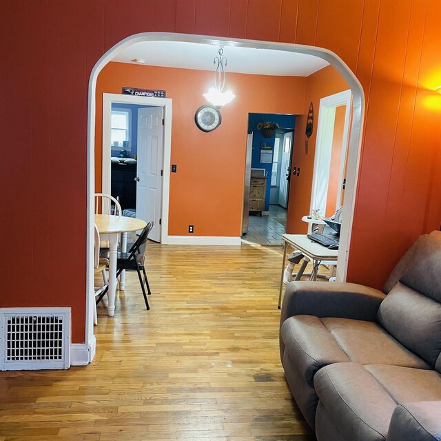326 N Oak St, Owosso, MI 48867 - living room featuring arched walkways, light wood finished floors, and baseboards