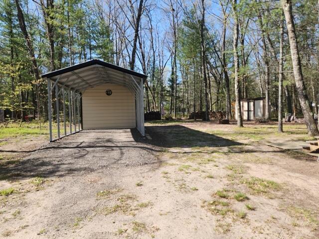 1631 W Lone Pine Rd, Baldwin, MI 49304 - view of yard featuring an outdoor structure, a carport, and a storage shed