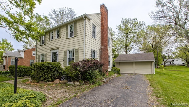 3070 Old Orchard Dr, Waterford, MI 48328 - view of front facade with a chimney, a detached garage, a front yard, and an outbuilding