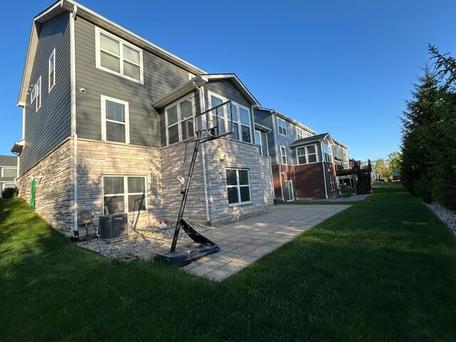 31065 Tremont Ln, Franklin, MI 48025 - back of property with stone siding, central air condition unit, a lawn, and a patio area