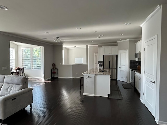 31065 Tremont Ln, Franklin, MI 48025 - kitchen with freestanding refrigerator, open floor plan, ornamental molding, a kitchen breakfast bar, and white cabinets