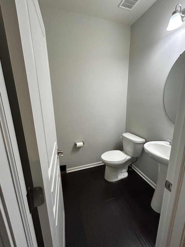 31065 Tremont Ln, Franklin, MI 48025 - half bathroom featuring toilet, baseboards, and wood finished floors