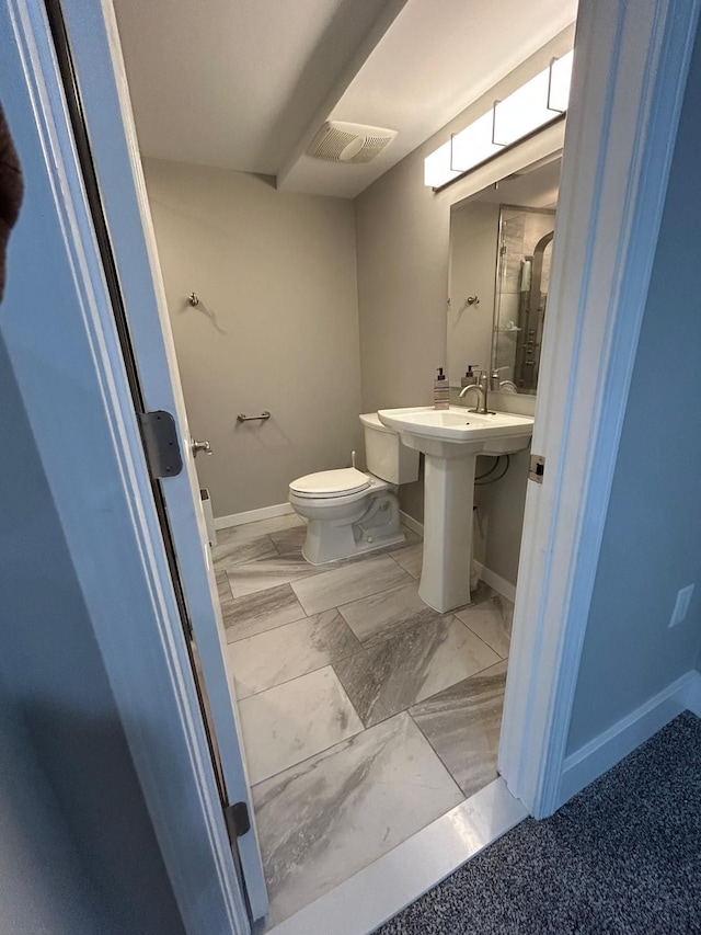 31065 Tremont Ln, Franklin, MI 48025 - bathroom with baseboards, toilet, and marble finish flooring