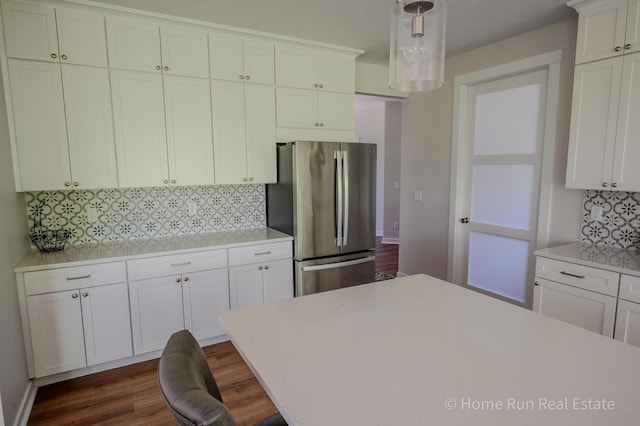 kitchen featuring freestanding refrigerator, backsplash, light countertops, and white cabinets